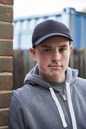 Portrait Of Teenage Boy Leaning Against Wall In Urban Settingの写真素材