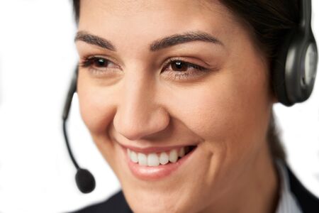 Close Up Of Businesswoman Wearing Telephone Headset In Customer Services Departmentの写真素材