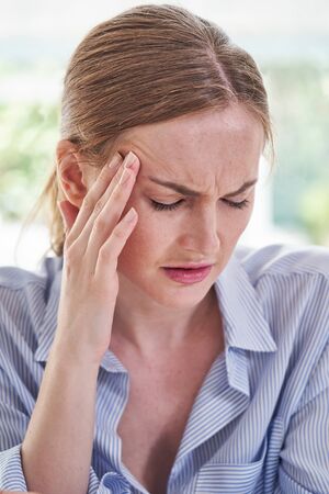 Stressed Businesswoman Suffering With Headache In Officeの写真素材