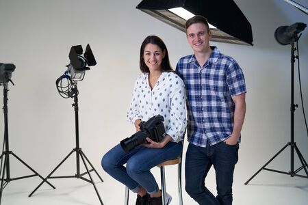 Portrait Of Female And Male Photographers In Studio For Photo Shoot With Camera And Lighting Equipmentの写真素材