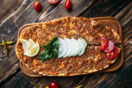 Turkish pizza lahmajun with minced meat on thin crust with vegetables and greens, horizontalの写真素材