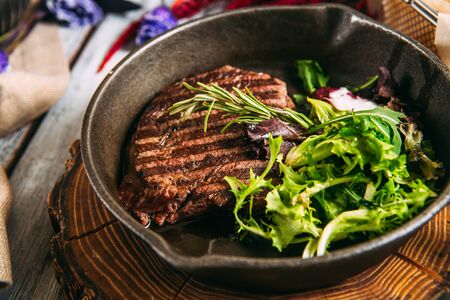 Closeup on appetizing juicy beef steak with greens in a pan, horizontal formatの写真素材