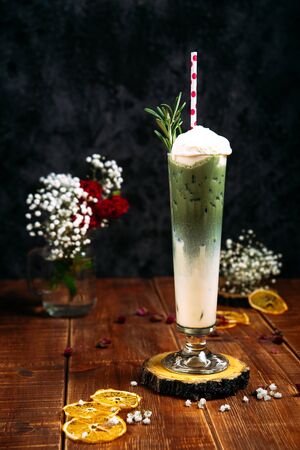 Appetizing sweet cool green milkshake cocktail in a glass on the wooden table, verticalの写真素材