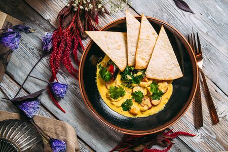 Seafood yellow cream soup with pita bread, top view, vertical formatの写真素材