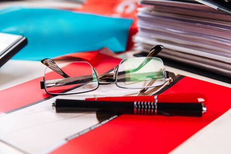 Office working place folders glasses red colour table, horizontalの写真素材