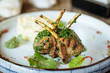 Closeup on fried lamb chops with mashed potato on the wooden table, horizontal