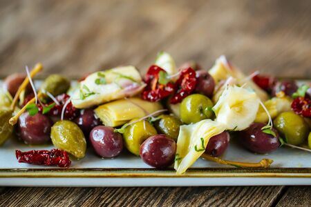 Close up on wine appetizers olives artichokes and sun-dried tomatoes, horizontalの写真素材