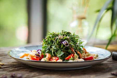 Gourmet salad with arugula and shrimps on the wooden table, horizontalの写真素材