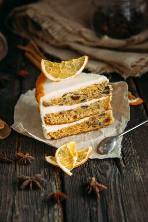 Delicious carrot cake with orange on the wooden table. vertical formatの写真素材