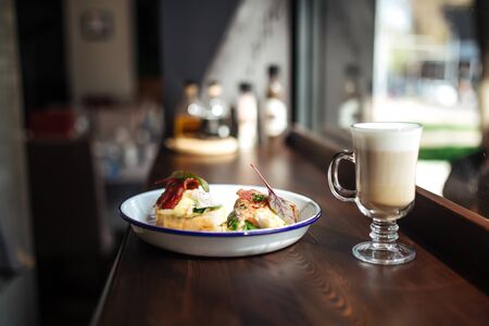 Morning breakfast bruschetta toasts with bacon fried eggs with coffee latte on the wooden table, horizontalの写真素材