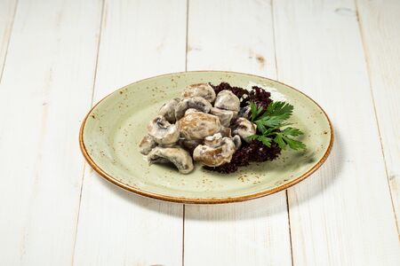 Appetizing cooked mushrooms with sauce on the white wooden bakcground, horizontalの写真素材