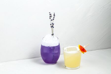 Beautiful delicious colourful decorated alcohol cocktail set in different glasses on the white background, horizontalの写真素材