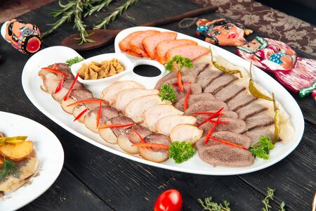 Closeup on asian meat sausages appetizer set beef tongue kazy on the dark wooden table, horizontalの写真素材