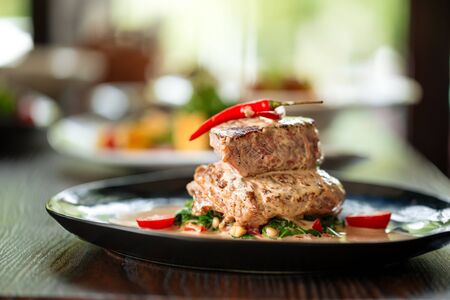 Closeup on appetizing fillet mignon steaks with sauce on the wooden table, horizontalの写真素材