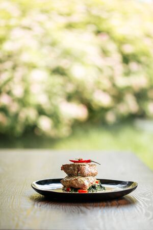 Side view on appetizing fillet mignon steaks with sauce on the wooden table, vertical