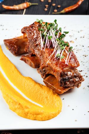 Closeup on gourmet stewed beef ribs with corn puree microgreen, verticalの写真素材