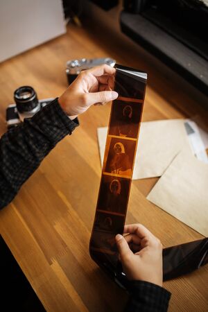 man is examines a medium format film. Vintage old. Verticalの写真素材