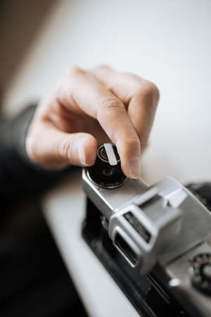 Male hand reloading film retro camera on a white table. Horizontal. top viewの写真素材