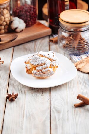 Sweet dessert profiterole sprinkled with powdered sugar, vertical