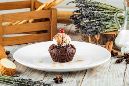 Sweet dessert chocolate muffin with a ball of ice cream decorated with cherry, horizontalの写真素材