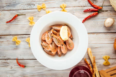 Top view on delicious appetizer roasted shrimps with lemon, horizontalの写真素材