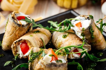 Closeup on appettizing snack eggplant rolls with tomatoes and garlic sauce, horizontalの写真素材