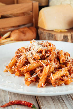 Closeup on italian penne pasta bolognese with beef and parmesan, verticalの写真素材