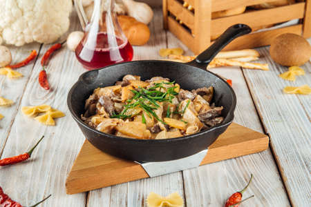 Fried potatoes with beef in cream sauce in a pan, horizontalの写真素材