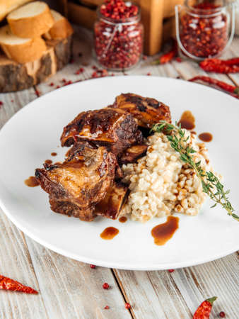 Closeup on gourmet beef stewed ribs with pearl barley risotto, verticalの写真素材