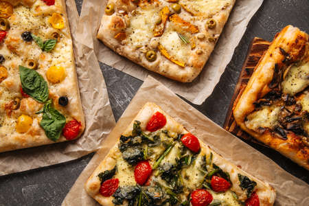 Top view on different italian focaccia bread with tomatoes spinach and olives, horizontal