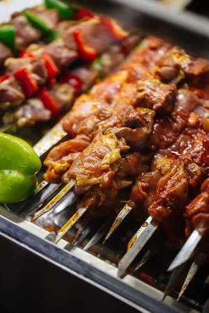 Selective focus on prepared raw skewers shashlyq to cook with lamb and vegetables