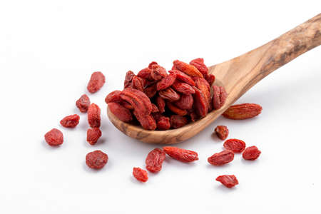Closeup on isolated red dried barberries in the wooden spoon