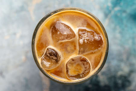 Top view on iced coffee in a glass on the blurry background