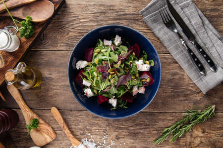 Top view on healthy vitamin salad with beetroot cheese and greens in a blue bowlの写真素材
