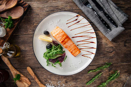 Top view on grilled salmon fillet steak with salad on the wooden tableの写真素材