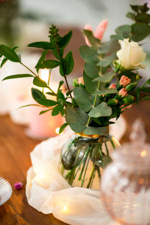 Romantic decorated wooden table with flowers candles and garlandの写真素材