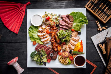 Top view on assorted grilled meat platter with beef chicken and vegetablesの写真素材