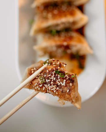 Eating cooked japanese gedza dumplings with soy sauce