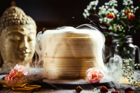 Side view on asian bamboo steamer on the decorated tableの写真素材