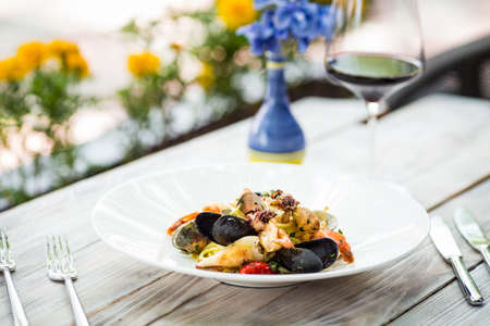 Closeup on appetizing italian cuisine restaurant dish seafood pasta on the white wooden table with...