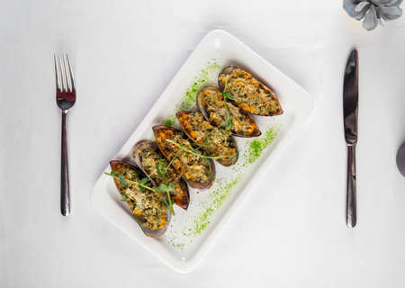 Top view on appetizing mussels with filling on the white table