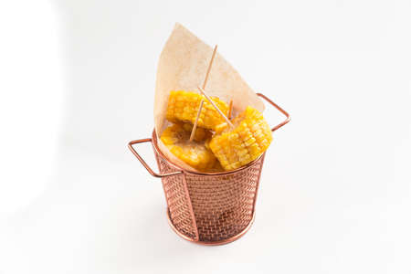Isolated cooked cut corn in a copper bucket with paperの写真素材