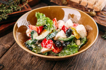 Closeup on greek salad with fresh vegetables cheese and olives in a bowlの写真素材
