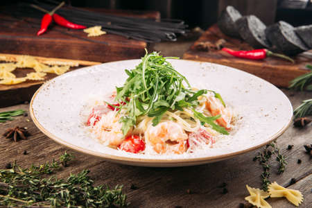 Closeup on spaghetti pasta with shrimp and arugula on the wooden tableの写真素材