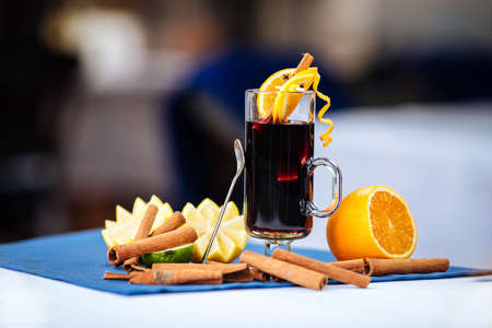 Classic mulled wine in a glass mug with orange and cinnamonの写真素材