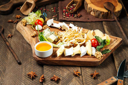 Side view on wine appetizers with cheese on the wooden board