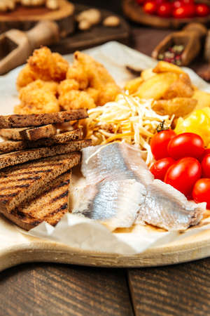 Closeup on russian snack set with herring and vegetables on the wooden boardの写真素材