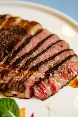 Closeup on grilled and sliced ribeye beef steak on a plateの写真素材