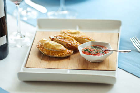 Spanish pies empanadas with sauce on the restaurant table