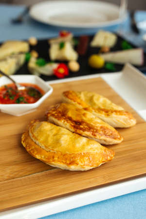 Closeup on spanish pies empanadas with sauce on the restaurant table